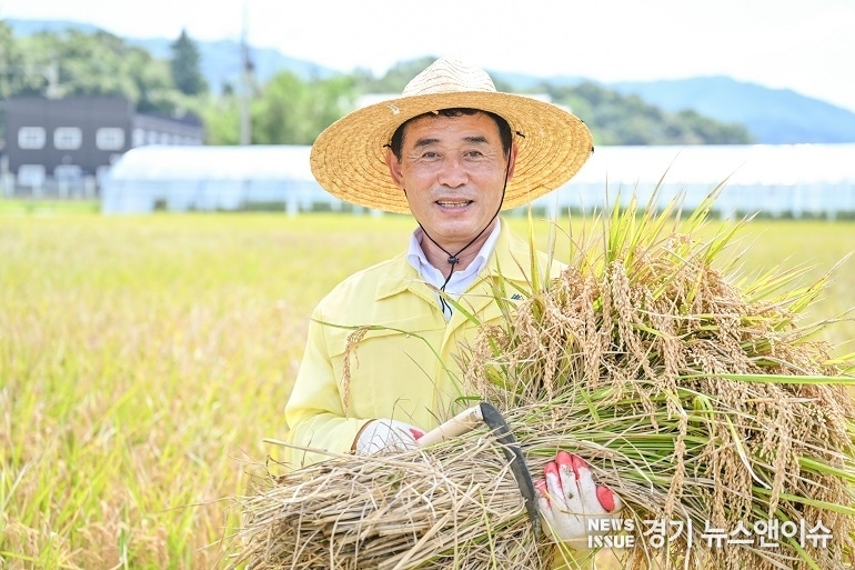 벼베기 행사에 참여한 백영현 포천시장이 수확한 벼를 품에 안고 기뻐하고 있다. (포천시 제공)